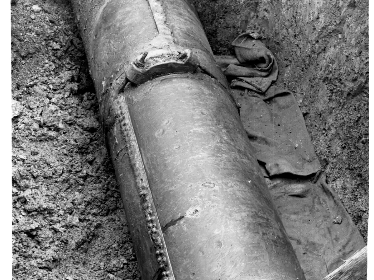 Grosse canalisation en fonte, dégagée dans une tranchée, vue de très près.